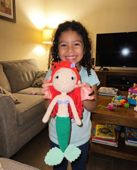 Niña mostrando orgullosa su muñeca sirena