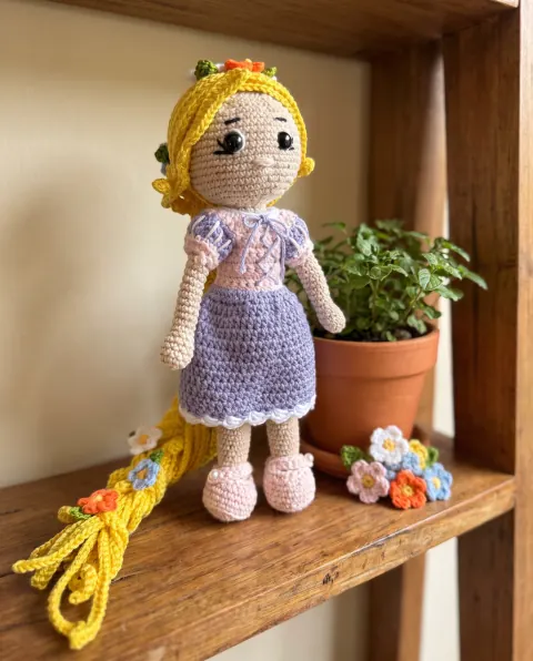 Muñeca tejida sobre una repisa de madera