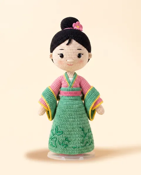 Muñeca de kimono verde y rosa con chongo negro y flor